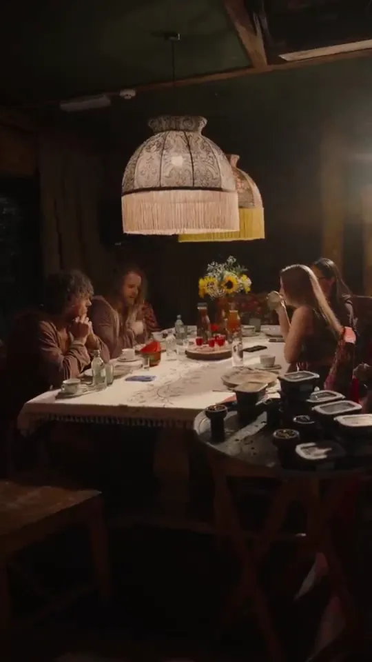 Long dinner table under fringed lamps in a rustic restaurant