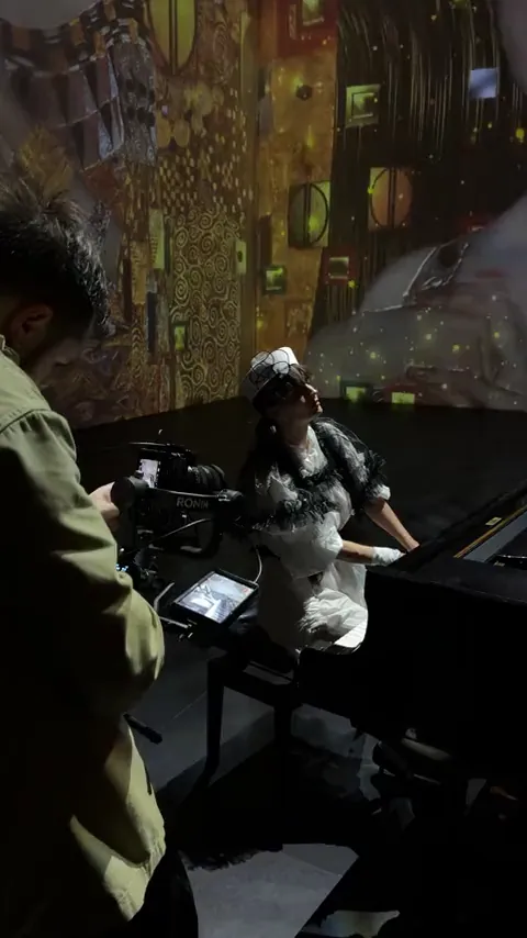 Camera operator filming a pianist in an immersive art room