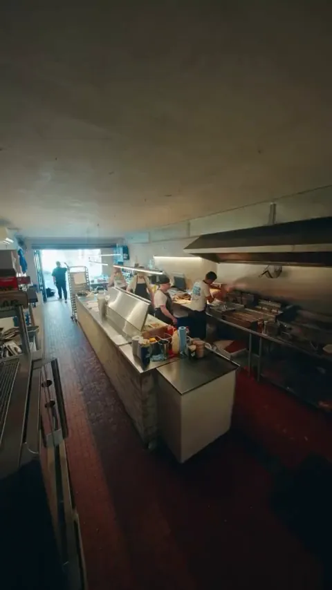 Wide shot of an open restaurant kitchen