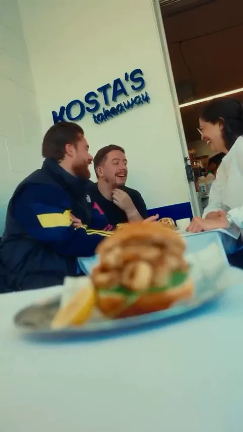 Seafood sandwich in focus with diners behind