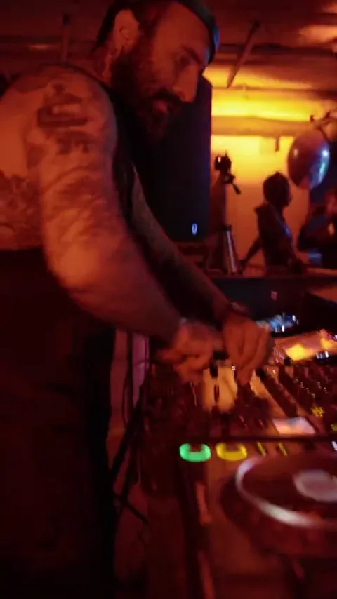 DJ at the decks in red club light