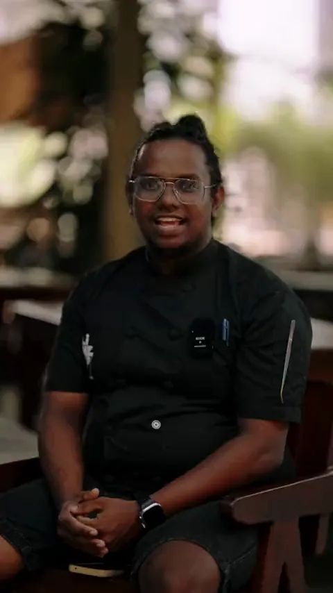Chef in a black jacket speaking on camera