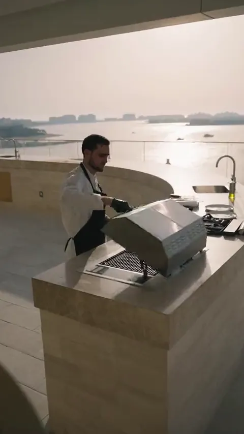 Chef grilling on a rooftop terrace by the sea